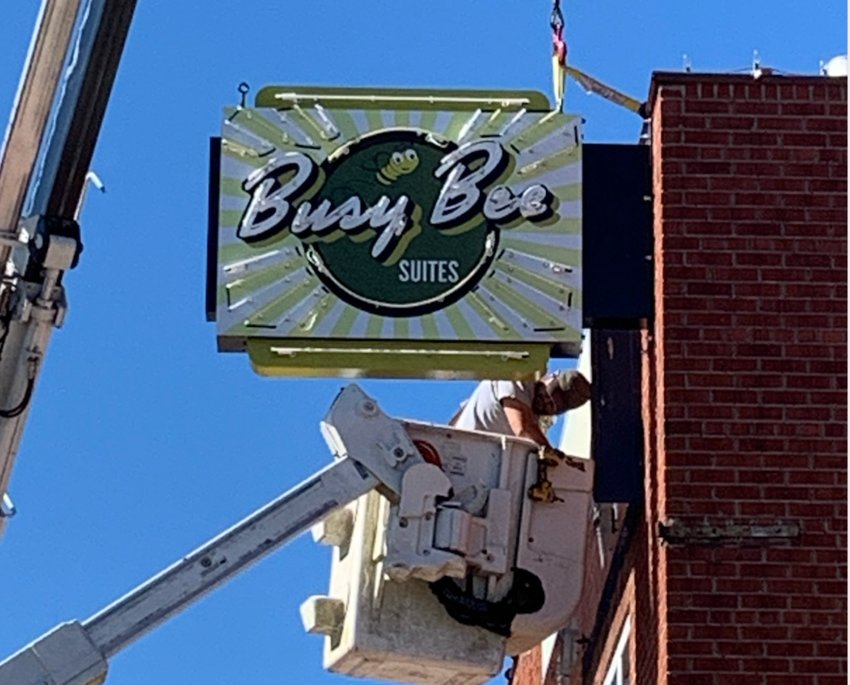 The Busy Bee Suites sign is going up in downtown Philadelphia at the corner of Beacon Street and Church Avenue this morning.